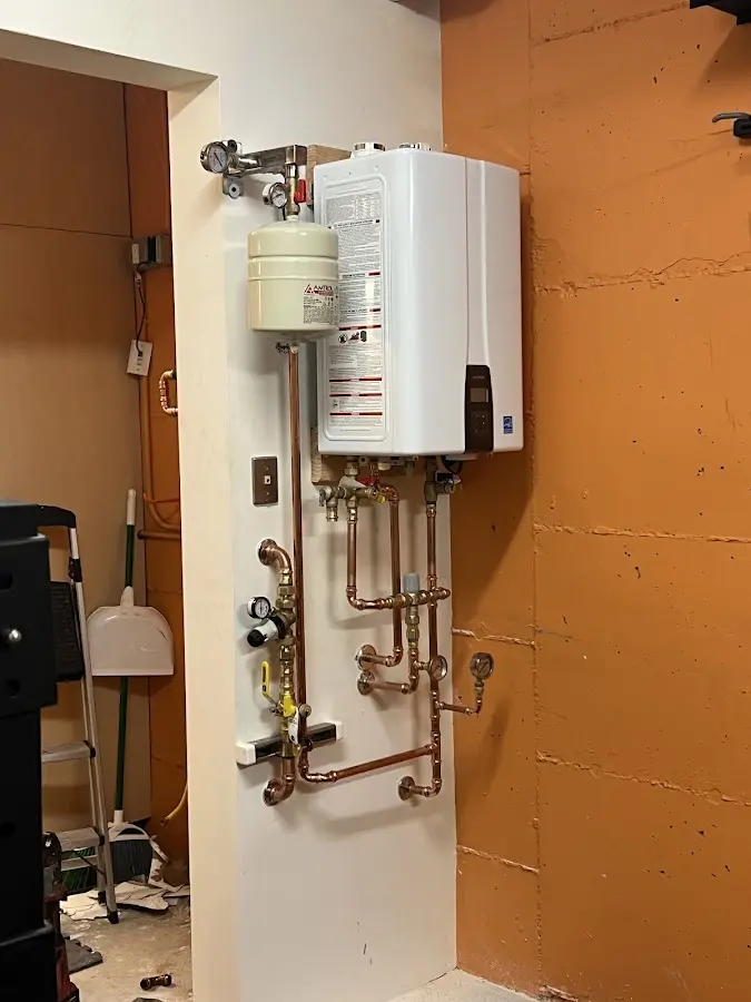 Plumbing technician inspecting water heater connections in Dimmitt